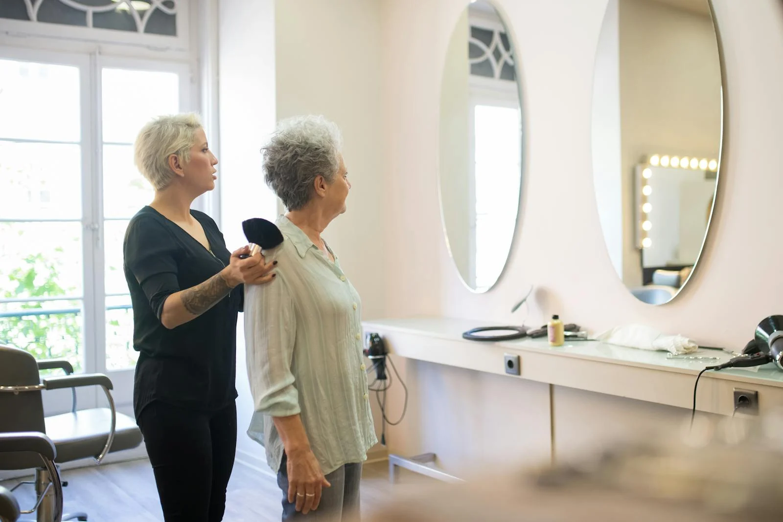 Estilista atendiendo a clienta en salón con sistema de reservas online